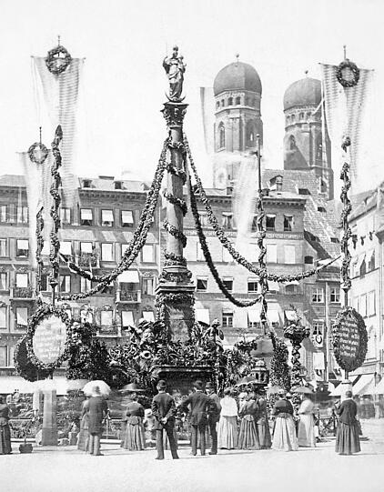 25. August 1880: Festlich geschm&uuml;ckt ist die Mariens&auml;ule zum Jubil&auml;um &bdquo;700 Jahre Wittelsbacher in Bayern&ldquo;. Hinten rechts: der imposante Bau vom alten Donisl.