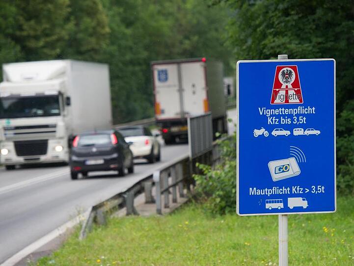 Autos und LKWs fahren an einem Hinweisschild zur Vignettenpflicht vorbei. Foto: Tobias Hase/dpa/Archivbild