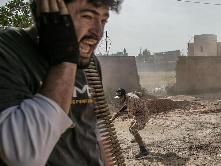 Kämpfer der Regierung gehen bei Zusammenstößen mit den Truppen der Libysch-Nationalen Armee in Deckung.