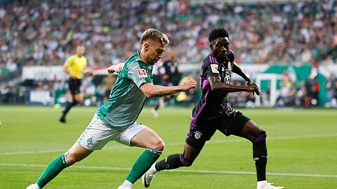 Bremens Mitchell Weiser (l) und Bayerns Alphonso Davies kämpfen um den Ball.