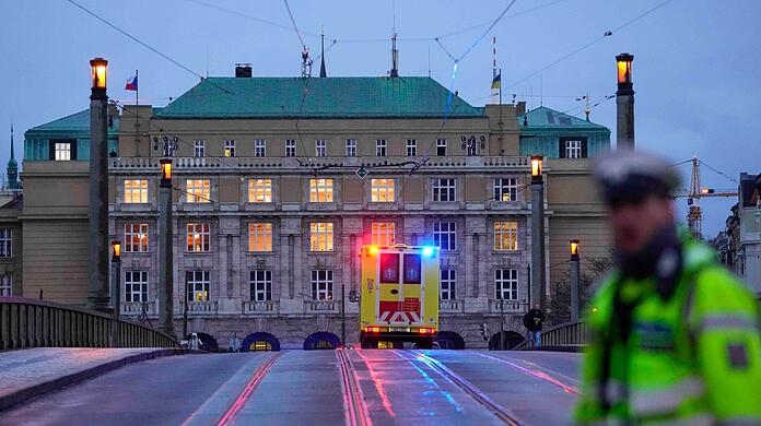 Ein Krankenwagen f&auml;hrt in Richtung des Geb&auml;udes der Philosophischen Fakult&auml;t der Karlsuniversit&auml;t.