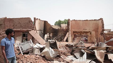 Ein Mann geht an einem Haus in Khartum vorbei, das bei den jüngsten Kämpfen im Sudan getroffen wurde.