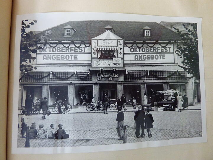 1950 begann AZ-Leser Friedrich Scholze (85) mit 14 Jahren eine Lehre als Schaufensterdekorateur beim Textilhaus Goetzke direkt am Weißenburger Platz.
"Es wurde viel handwerklich gearbeitet, tapezieren, Blickfang bauen, dekorieren und Plakat malen", erinnert er sich. Zu jedem Anlass habe es damals eine Außenreklame gegeben, die die Mitarbeiter bemalten und montierten.

Zur Wiesn sieht es festlich aus, das Textilhaus Goetzke. Heute steht hier ein Ärztehaus mit Bankfiliale.