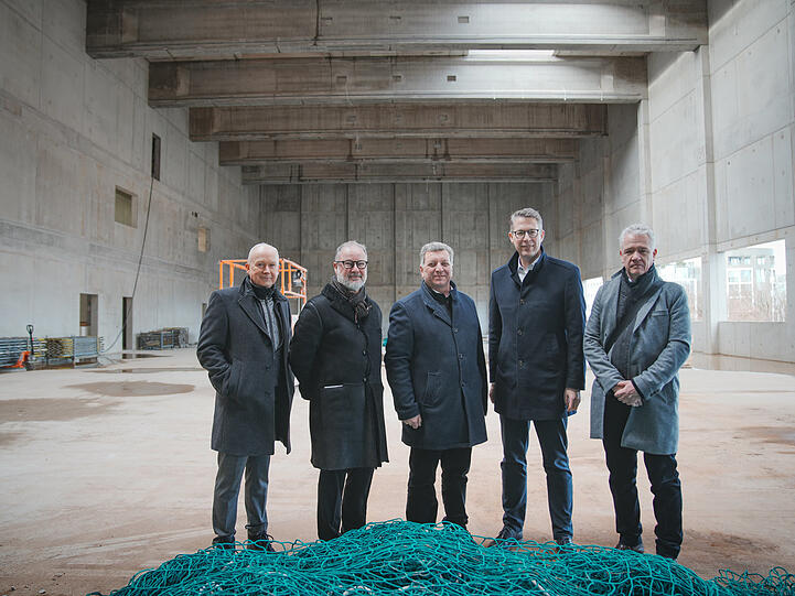 Karl Stock (Staatliches Bauamt Regensburg, von links), Andreas Beck (Intendant), Christian Bernreiter (Bauminister), Markus Blume (Kunstminister), Matthias Jakob (Implenia) im zukünftigen Malsaal des Staatsschauspiels.