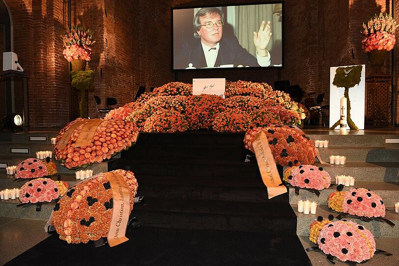 Der Sarg von Gerd Käfer liegt in einem orangefarbenen Blumenmeer
