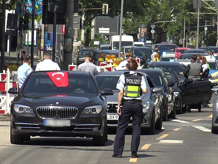 Eine Polizistin steht vor den Autos eines Autokorsos. Foto: Thomas Kraus/Archivbild