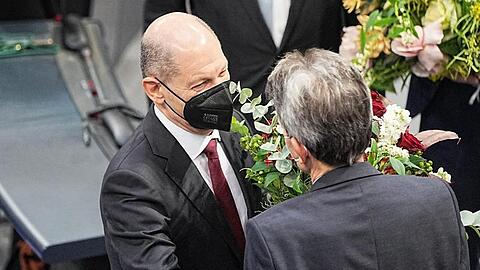 Bundeskanzler Olaf Scholz (l) erhält vom SPD-Fraktionschef Rolf Mützenich einen Blumenstrauß.
