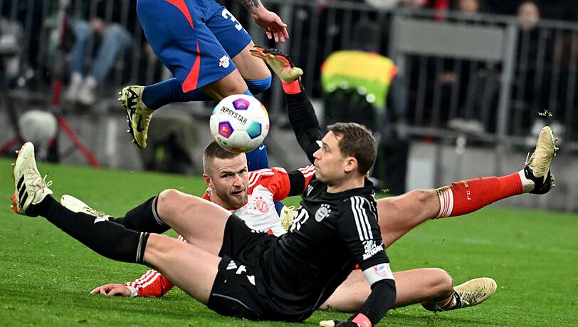 Bayerns Torhüter Manuel Neuer (r) pariert den Ball von Benjamin Sesko (l).