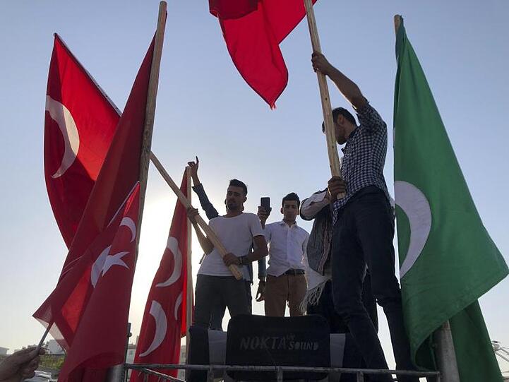 Männer schwenken in Akçakale Nationalflaggen und feiern die Erfolge der türkischen Truppen.