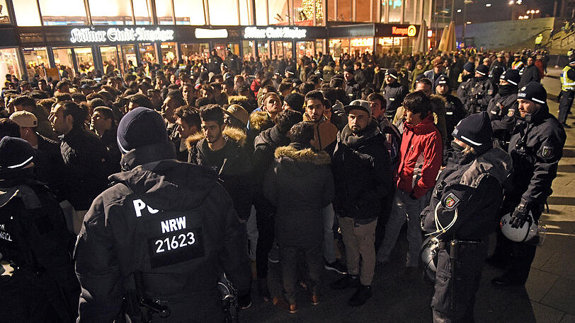 Polizisten umringen am 31.12.2016 vor dem Hauptbahnhof in Köln (Nordrhein-Westfalen) eine Gruppe südländisch aussehender Männer.