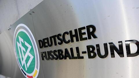 Logo und Schriftzug sind vor der Zentrale des Deutschen Fußball-Bundes (DFB) an einer Mauer platziert. Foto: Arne Dedert/dpa/Archivbild