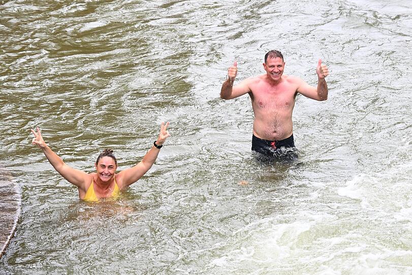 Oktobersamstag in München: Australier Ian Tomlinson (r.) und seine Kollegin freuen sich bei schönem Wetter im Eisbach über ein Bad.