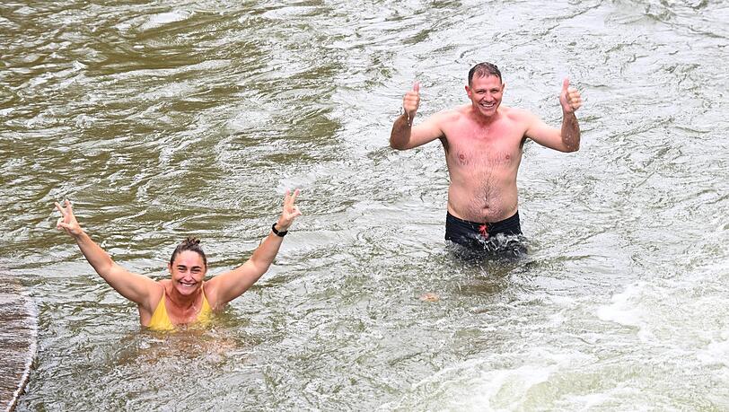 Oktobersamstag in München: Australier Ian Tomlinson (r.) und seine Kollegin freuen sich bei schönem Wetter im Eisbach über ein Bad. Oktobersamstag in München: Australier Ian Tomlinson (r.) und seine Kollegin freuen sich bei schönem Wetter im Eisbach über ein Bad.