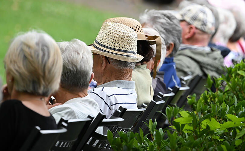 &Auml;ltere Menschen sitzen nebeneinander w&auml;hrend eines Konzertbesuches.