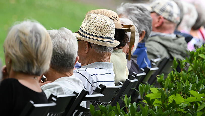 &Auml;ltere Menschen sitzen nebeneinander w&auml;hrend eines Konzertbesuches.