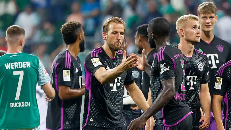 Bayerns Harry Kane (M) klatscht mit Bayerns Dayot Upamecano nach dem Spiel ab.