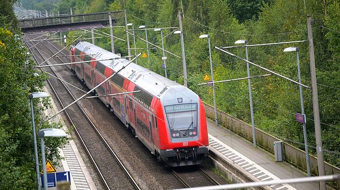Ein Regionalzug der Deutschen Bahn fährt durch einen Bahnhof.