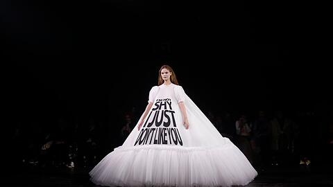 Ein Model trägt eine Kreation aus der Frühjahr/Sommer 2019 Haute Couture Modekollektion von Viktor & Rolf mit der Aufschrift "Ich bin nicht schüchtern, ich mag dich nur nicht".