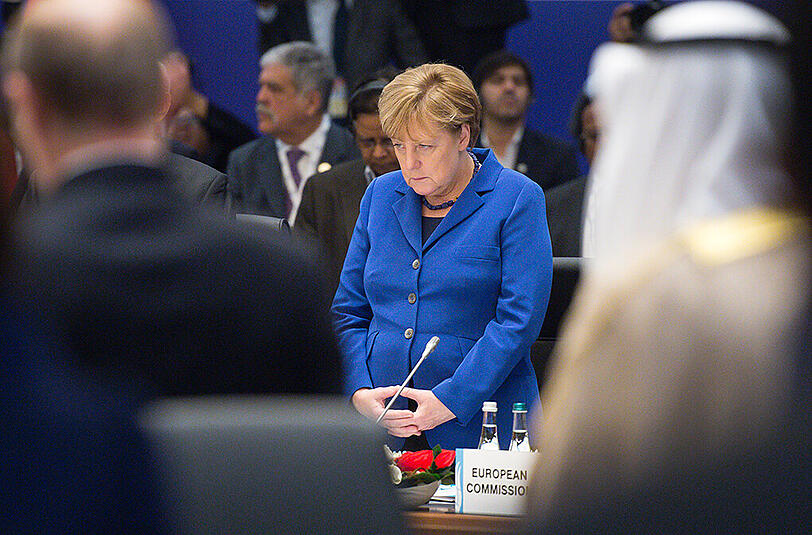 Bundeskanzlerin Angela Merkel (CDU) beim G20-Gipfel in Belek bei Antalya zu Beginn der Sitzung bei einer Schweigeminute für die Opfer der Terroranschläge in Paris. Links im Vordergrund steht der russische Präsident Wladimir Putin.
