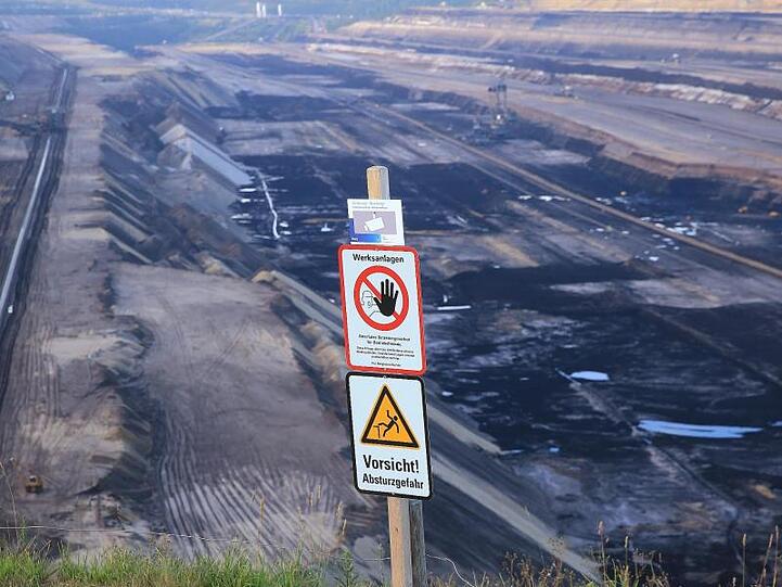 Warnschild an der Abbruchkante des Tagebaus Garzweiler: RWE warnt vor lebensgefährlichen Risiken auf seinem Betriebsgelände.