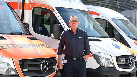 Peter Aicher vor seinem Fuhrpark. Er setzt sich auch mal selbst hinters Steuer.
