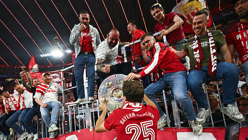 Münchens Thomas Müller reicht die Meisterschale den Fans.