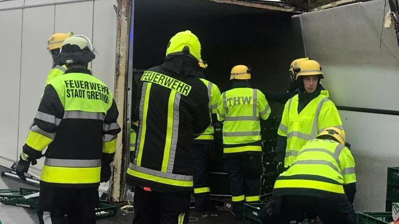 Einsatzkräfte von Feuerwehr und technischem Hilfswerk (THW) entladen einem umgestürtzten LKW. Foto: Andy Eberlein/dpa