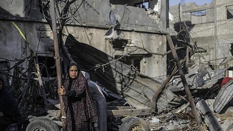 Eine Frau vor Trümmern in der Stadt Beit Chanun im Norden des Gazastreifens. Der Konflikt zwischen Israelis und Palästinensern kann nach Ansicht von US-Präsident Joe Biden langfristig nur durch eine Zweistaatenlösung befriedet werden.