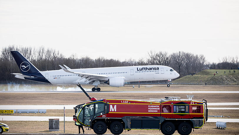 Ein Airbus A350-900, davor ist ein L&ouml;schfahrzeug der Flughafenfeuerwehr zu sehen (Symbolbild).