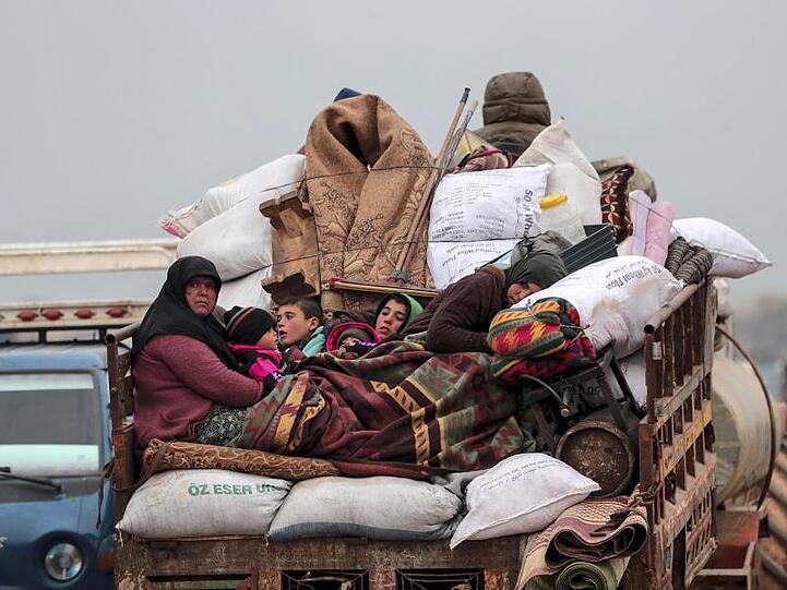 Zivilisten auf der Ladefläche eines Fahrzeugs bei der Flucht aus Idlib.