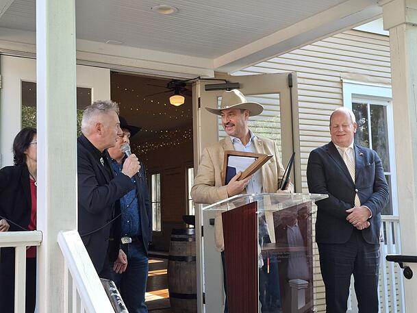 Kai Hennig (l.), der deutsche Generalkonsul in Houston, spricht zu Ministerpr&auml;sident Markus S&ouml;der, der wie ein echter Texaner eingedeckt worden ist.