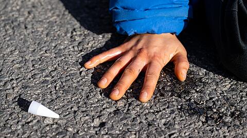 Klimaaktivisten haben sich am Karlsplatz in der Innenstadt auf die Fahrbahn geklebt und blockieren die Straße.