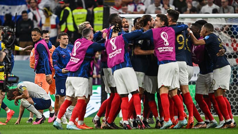 Die französischen Spieler feiern den Sieg, Englands Harry Kane (l) kauert auf dem Rasen.