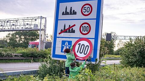 Auf Autobahnen gilt ... ein Tempo-100-Tempolimit? So zumindest wollen es Greenpeace-Aktivistinnen, hier bei der Aktion am Montagmorgen in Aachen.
