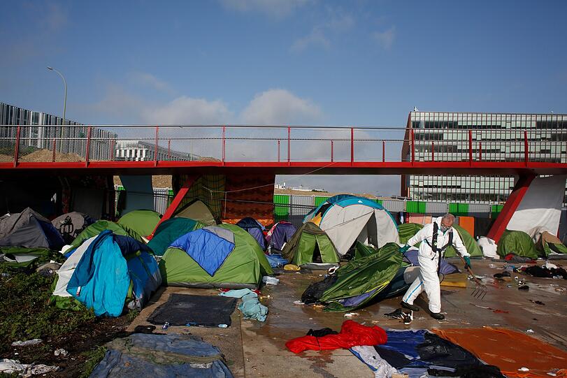 Paris: Ein Mitarbeiter der Stadt zieht ein Zelt hinter sich her, während der Räumung eines Migranten-Zeltlagers. Nach wochenlangem Streit räumt die französische Polizei das größte illegale Migranten-Zeltlager in Paris.