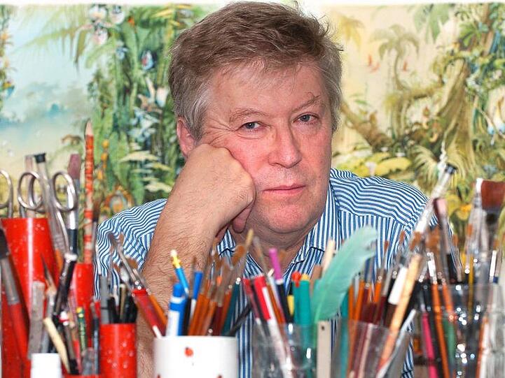 Der Karikaturist Horst Haitzinger schaut über seinen Arbeitstisch voll mit Stiften. Foto: Peter Kneffel/dpa