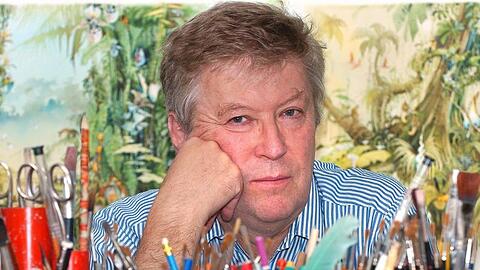 Der Karikaturist Horst Haitzinger schaut über seinen Arbeitstisch voll mit Stiften. Foto: Peter Kneffel/dpa