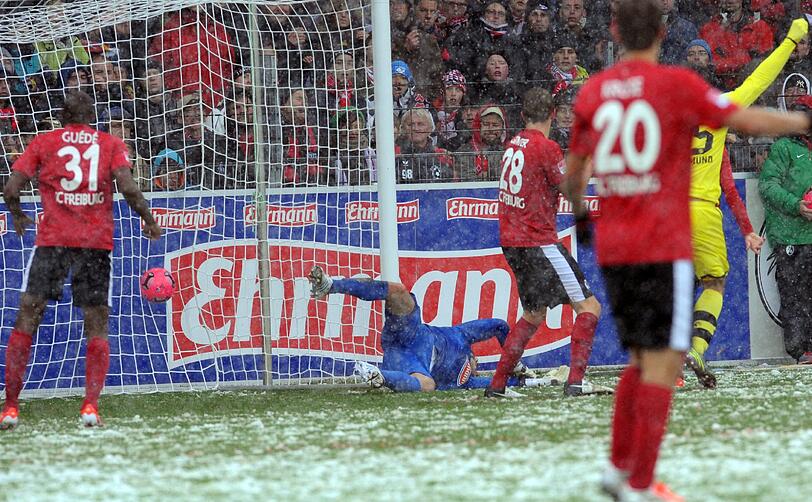 Die Bilder aus Freiburg. Die Linien müssen freigeräumt werden, der Ball ist rot und Spieler wie Trainer sind nicht zu beneiden. Doch dennoch wird gespielt.