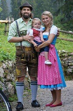 EHC-Stürmer Ty Morris in Tracht mit seiner Frau Verena und Tochter Leni.