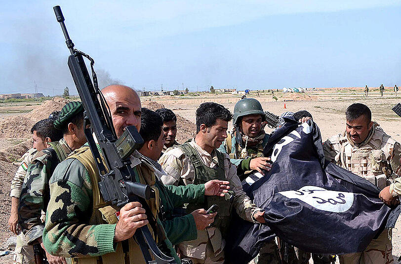 Kurdische Peschmerga-Kämpfer nach einem Teil-Sieg gegen den IS. Einer hält ein G36-Sturmgewehr in die Kamera.