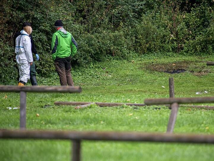 Ermittler der Polizei stehen unmittelbar neben dem Fundort der verkohlten Frauenleiche am Feringasee in Unterföhring. Foto: Matthias Balk/Archiv
