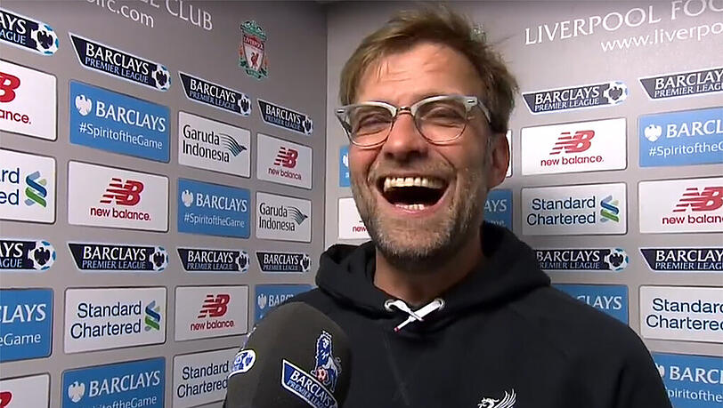 Hat gut lachen: Jürgen Klopp bekommt im Liverpool-Fanshop sein eigenes Shirt. Hat gut lachen: Jürgen Klopp bekommt im Liverpool-Fanshop sein eigenes Shirt.