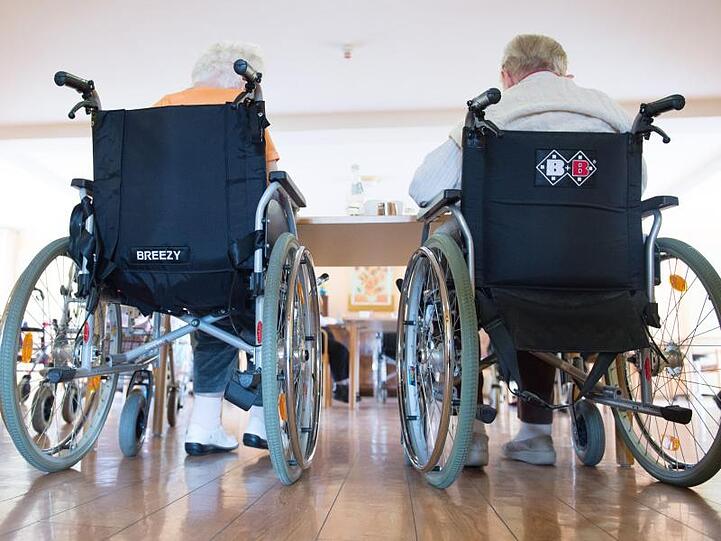 Zwei pflegebedürftige Frauen sitzen in einem Pflegeheim in ihren Rollstühlen nebeneinander. Foto: Sebastian Kahnert/dpa-Zentralbild/dpa/Symbolbild