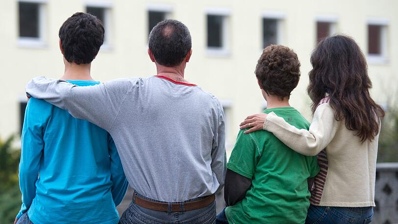 Eine syrische Familie sitzt vor einem Asylwohnheim der Zentralen Ausländerbehörde des Landes Brandenburg.