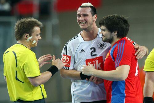 Pascal Hens (Mi.) umarmt hier zwar nach dem 26:26 seinen russischen Gegenspieler, zufrieden mit dem WM-Auftaktspiel war er aber nicht.