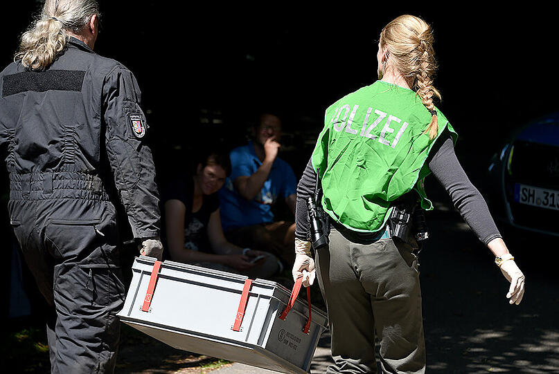 Polizeibeamte gehen am 01.07.2015 in Heikendorf (Schleswig-Holstein) zu einem Villengrundstück. Auf dem Gelände sollen sich Waffen aus dem Zweiten Weltkrieg befinden.