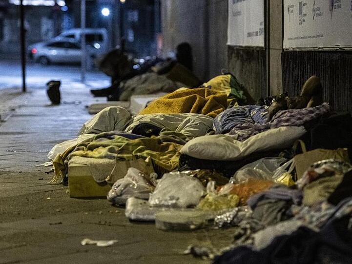 Obdachlose Menschen liegen unter einer Brücke am Bahnhof Zoo.