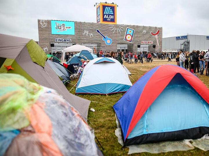 Zelte stehen auf dem Gelände des Southside Festivals vor einer eigens für das Festival erbauten Aldi Süd Filiale.