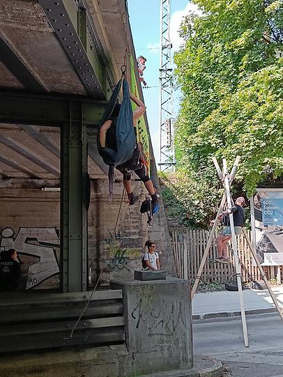 Ein Mann baumelt von der Eisenbahnbrücke.