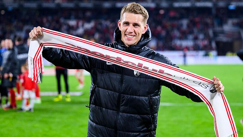 Freiburgs Nils Petersen hat nach dem Spiel ein Fan-Schal in der Hand und wird verabschiedet.